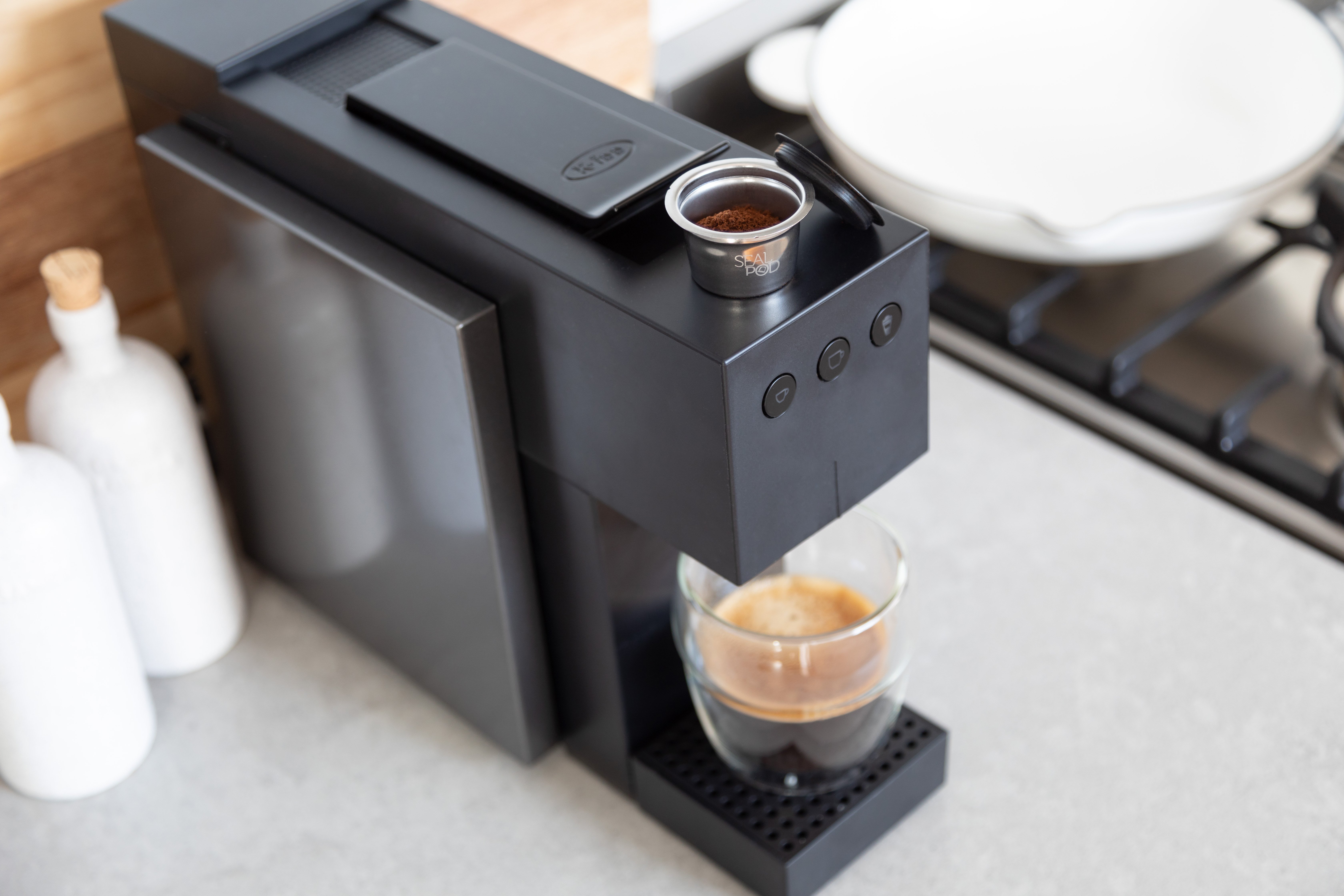 A Cream Joe reusable coffee pod sitting on a coffee machine