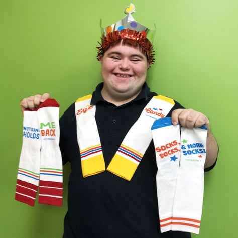 John Cronin (John's Crazy Socks) wearing crown and holding socks